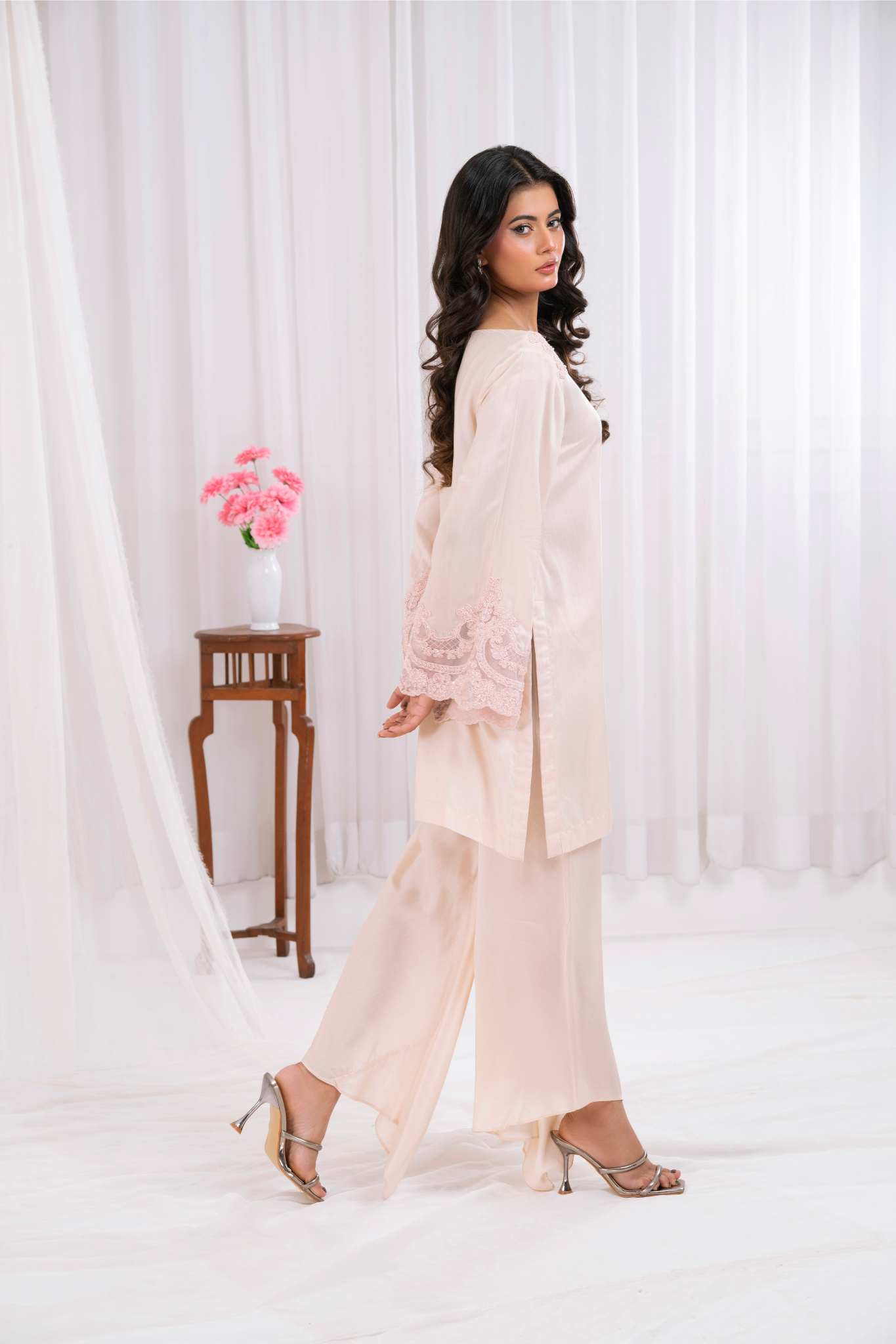 blush pink ensemble, featuring delicate lacework on the neckline and bell sleeves.