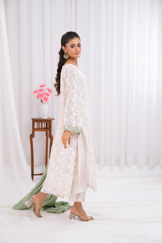 Embroidered fabric with apple green lace appliqué in a donut motif.