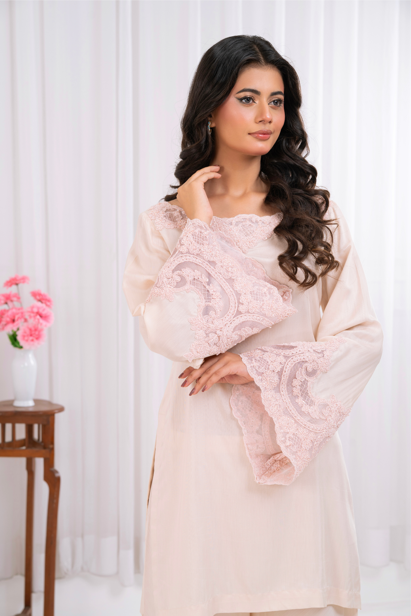 blush pink ensemble, featuring delicate lacework on the neckline and bell sleeves.