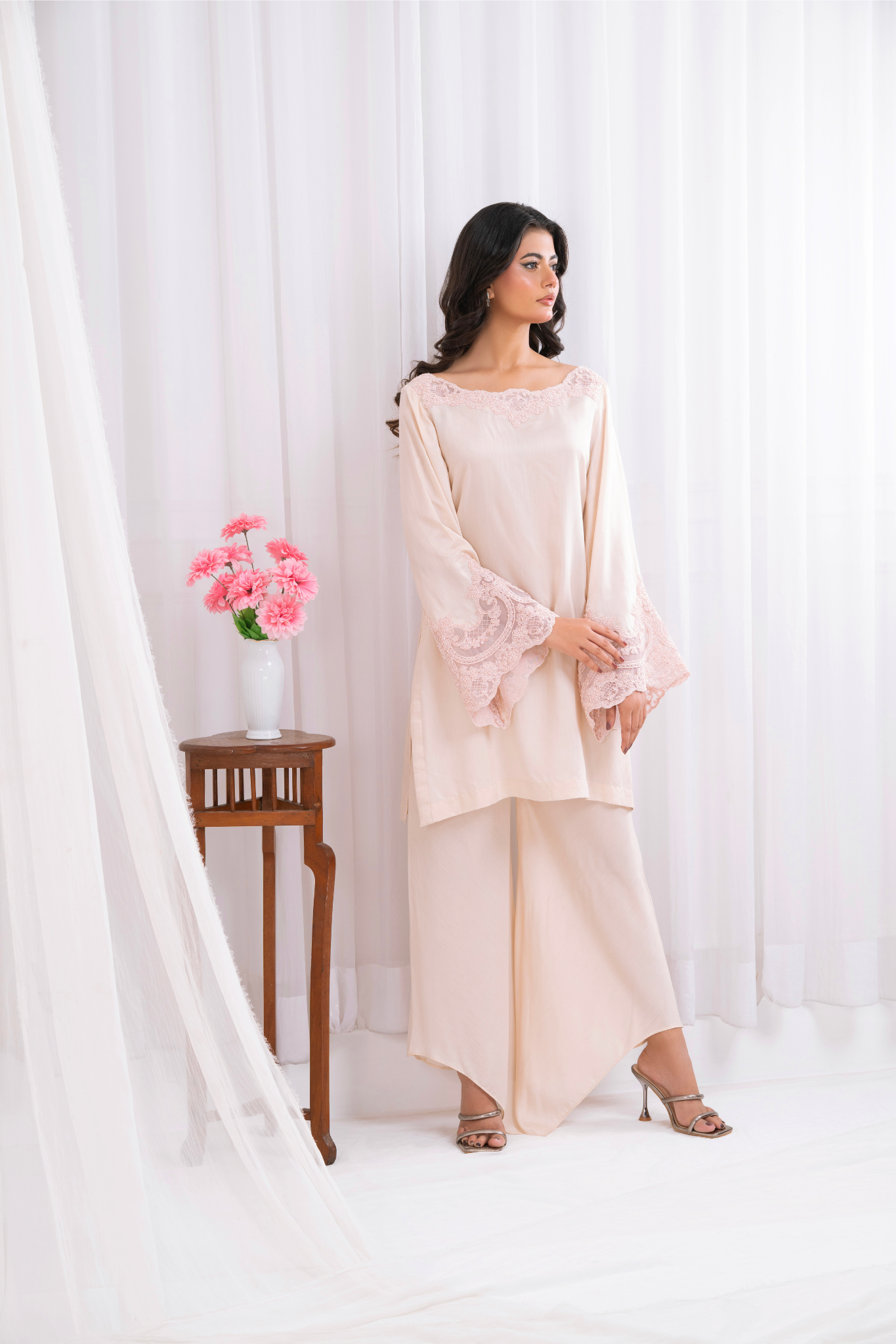 blush pink ensemble, featuring delicate lacework on the neckline and bell sleeves.