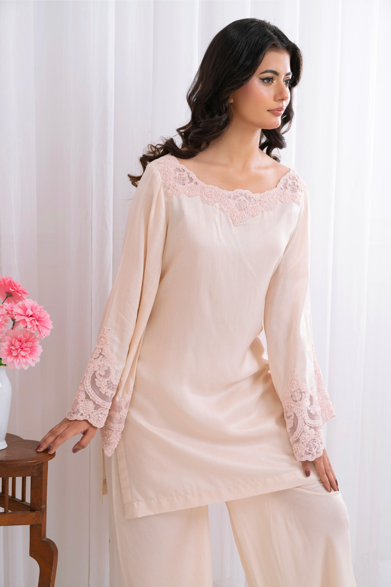 blush pink ensemble, featuring delicate lacework on the neckline and bell sleeves.